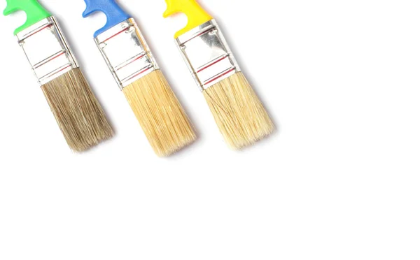 Flat lay close-up of color paint brushes on a white background, copy space. — Stock Photo, Image