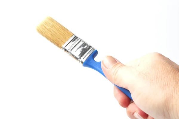 Paint brush with a blue handle in the right hand of a worker, close-up, white background. — 스톡 사진