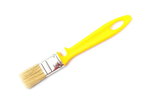 Pincel de pintura com uma alça amarela close-up em um fundo branco . — Fotografia de Stock