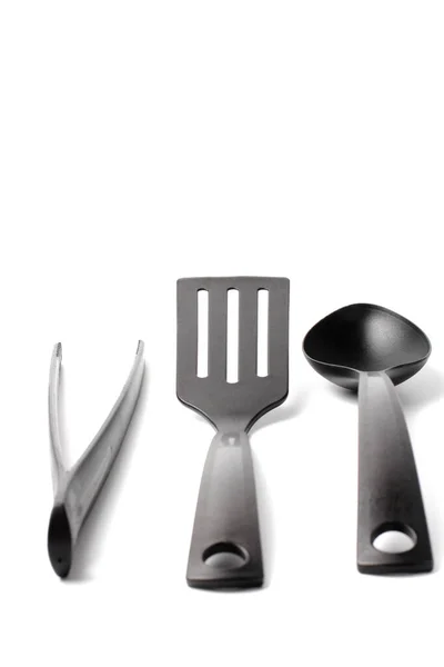 Közelkép kanál, spatula és szakács csipeszek fehér alapon, másolás tér — Stock Fotó