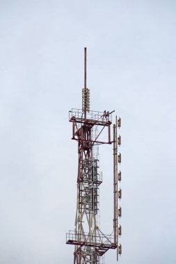 Bulutlu bir gökyüzüne karşı yayın yapan cep telefonu ya da televizyon anteni.