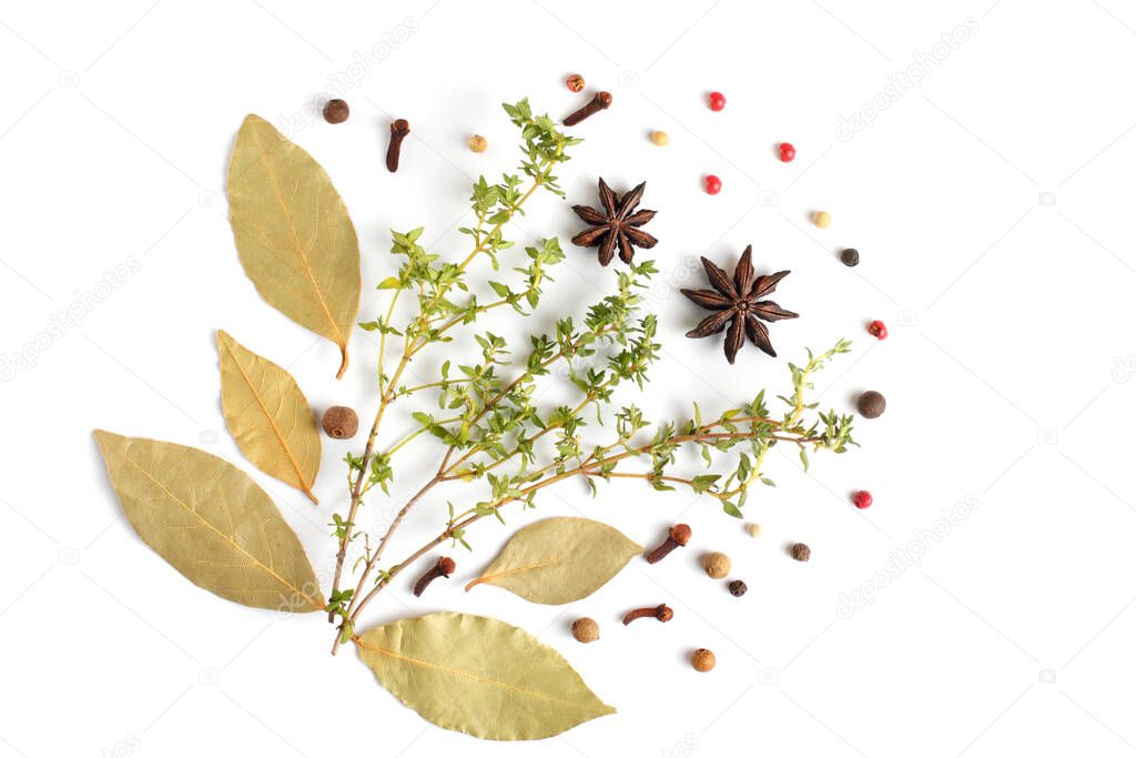 Bay leaf, thyme, peppercorns, cloves, star anise, herbs and spices on a white background, flat lay, top view.