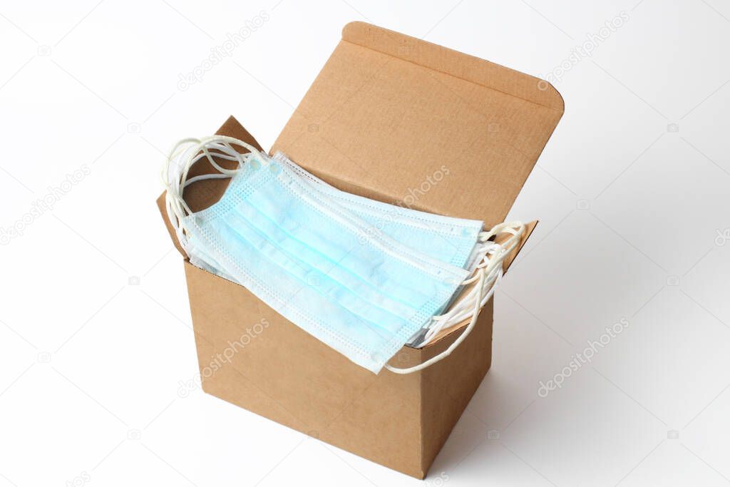 Medical masks in a box on a white background close-up, coronavirus concept and other contagious diseases.