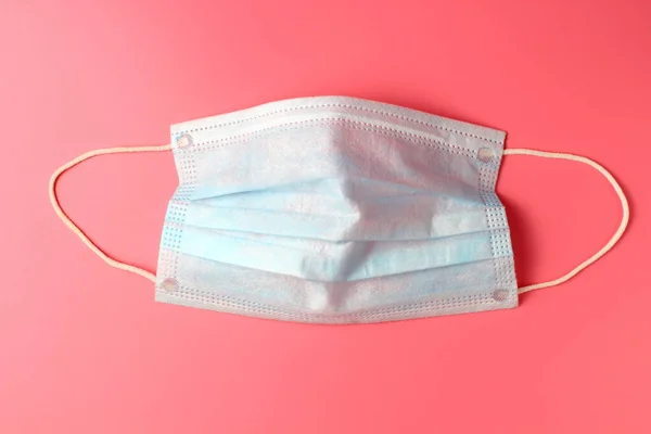 Medical masks on a pink background close-up, flat lay, the concept of the fight against coronovirus and other infectious diseases.