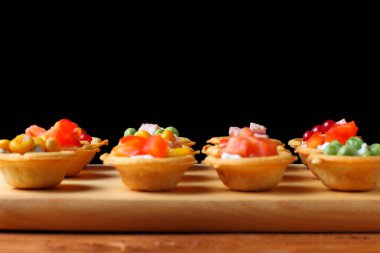 Hafif atıştırmalıklar, turtalar, tapalar, bira veya şarap veya elma şarabı, koyu kırsal arka plan, siyah zemin, üst görünüm, kopyalama alanı.