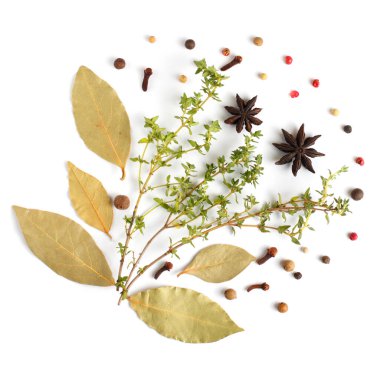 Beyaz arka planda mis kokulu bitkiler ve baharatlar. Koyun yaprağı, karanfil, tüm baharatlar, kekik. Düz yatış, üst görünüm.