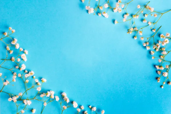 Gypsophila flowers on blue background. Flowers pattern composition. Spring concept. Flat lay, top view, copy space.