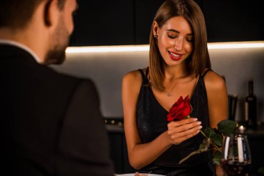 Genç ve güzel bir çift evde romantik bir akşam yemeği yiyor. Çekici kız, Rose 'la sevgilisinden zevk alıyor.