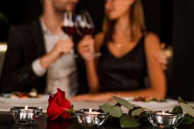 Gül ve mumlara odaklanmış romantik bir akşam yemeği randevusu.