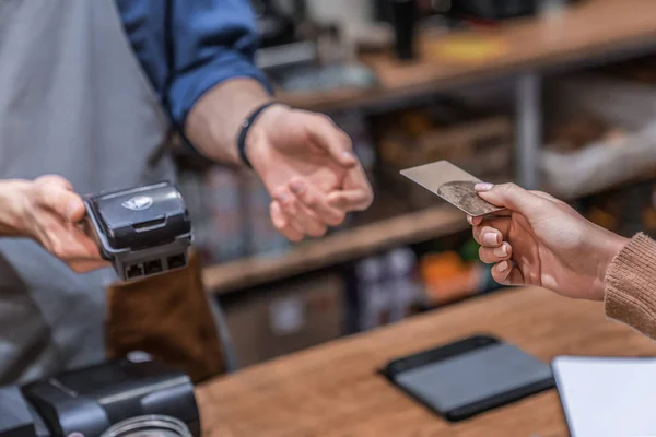 Foto close up dipotong dari pelanggan perempuan lewat kartu kreditnya kepada pekerja warung kopi — Stok Foto