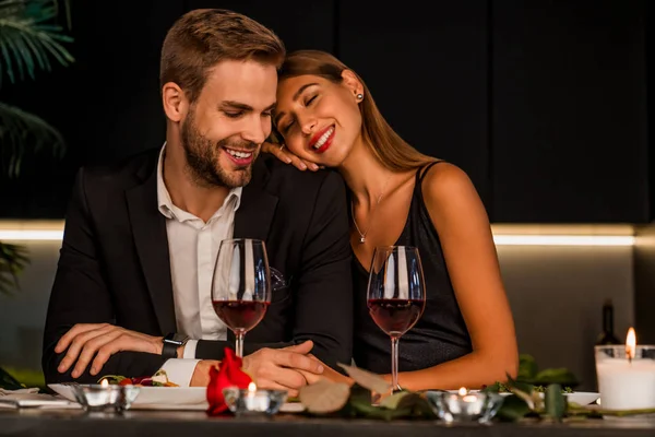 Aufgeregtes Liebespaar feiert besonderes Ereignis mit Wein und Kerzen, gemeinsames Abendessen — Stockfoto