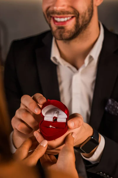 Close up shot of smiling man asking hand of his girlfriend with an engagement ring — ストック写真