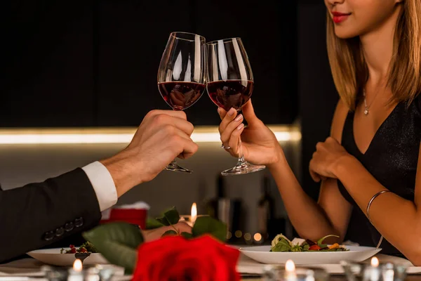 Молода щаслива пара вітає в келихах червоного вина — стокове фото