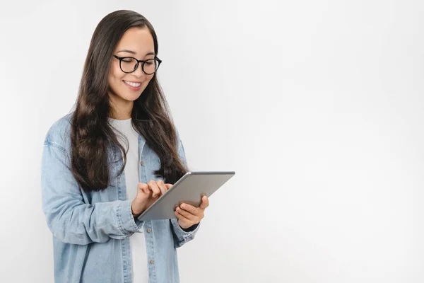 Улыбающаяся молодая женщина с помощью планшетного компьютера изолированы на белом фоне — стоковое фото