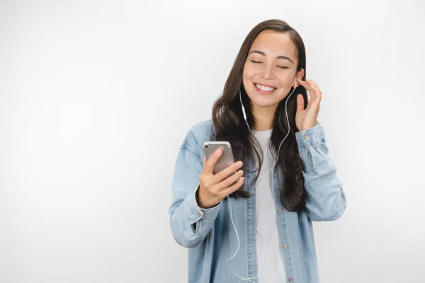 Portrait of cheerful cute woman listening music in headphone isolated on a white background . — Stok Foto