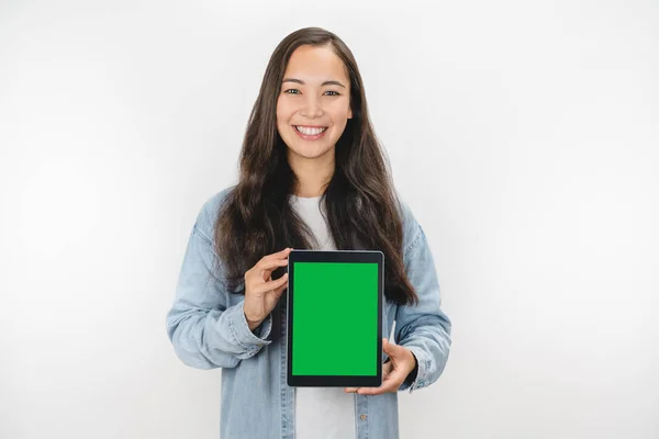 Молодая азиатка показывает планшетный компьютер на белом фоне — стоковое фото