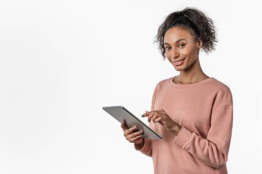 Beyaz arka plan üzerinde izole edilmiş tablet bilgisayar kullanan Afrikalı genç bir kadın.
