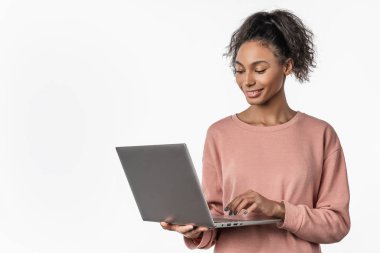Sırıtkan kadın elinde dizüstü bilgisayarla beyaz arka planda e-posta yolluyor.