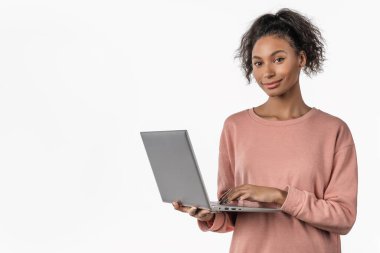 Beyaz arka planda izole edilmiş dizüstü bilgisayar kullanan mutlu Afrikalı genç kız.