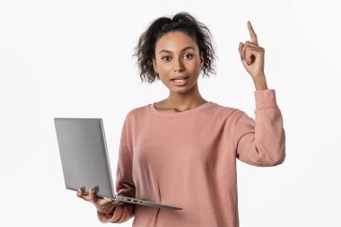 Heyecanlı genç bir kadın dizüstü bilgisayar kullanarak beyaz arka plan üzerinde izole edilmiş bir fikir ediniyor.