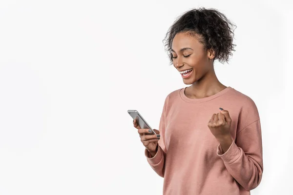 Mujer africana feliz celebrando con teléfono móvil aislado sobre fondo blanco — Foto de Stock