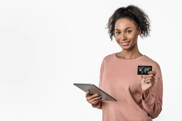 Ung kvinna som använder surfplatta online shopping med kreditkort ler i casual kläder över vit bakgrund skott — Stockfoto
