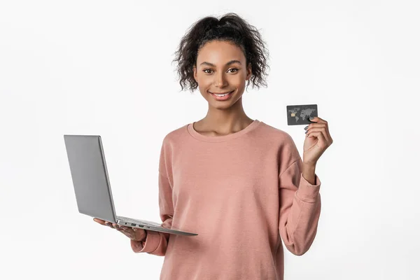 Portrait of happy woman holding credit card and laptop isolated over white background — Stock Photo, Image