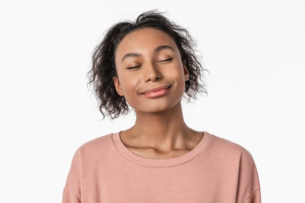 Retrato de bonito jovem mulher com fechado olhos sonhando enquanto em pé sobre branco fundo — Fotografia de Stock