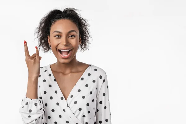 Femme à la peau foncée fait signe rock n roll se tient sur fond blanc — Photo