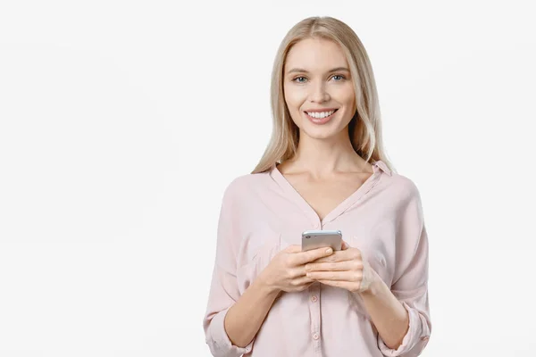 Retrato de mujer sonriente en casual usando teléfono inteligente sobre fondo blanco — Foto de Stock