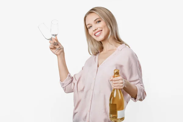 Glückliches junges Mädchen feiert mit einer Flasche Champagner und zwei Gläsern, die isoliert vor weißem Hintergrund stehen — Stockfoto