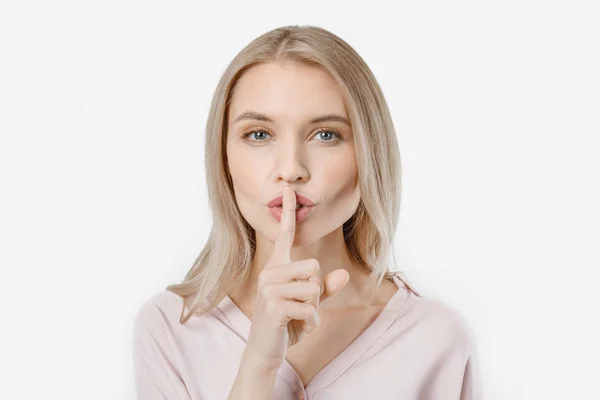 Portret atrakcyjnej dziewczyny z palcem na ustach na białym tle — Zdjęcie stockowe