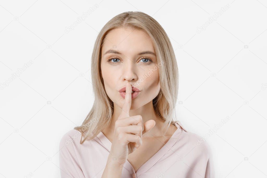 Portrait of attractive girl with finger on lips isolated over white background