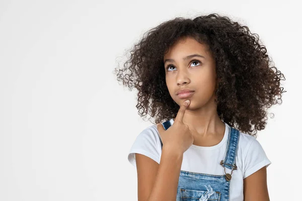 Petite fille réfléchie touchant le menton avec la pensée du doigt isolé sur fond de studio blanc — Photo