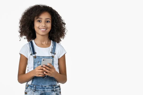 Pequeña adolescente sonriente usando teléfono móvil aislado sobre fondo blanco — Foto de Stock