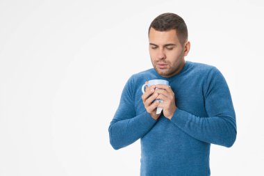 Young man feeling sick with cup on white background