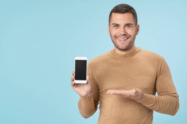 Man presenting smartphone with black screen with copy space isolated on blue background