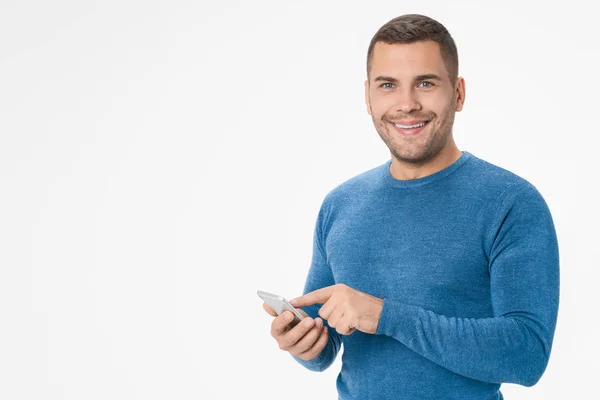 Cheerful young man using mobile phone isolated over white background — ストック写真