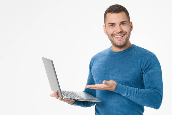 Joven sosteniendo el ordenador portátil y mostrando el ordenador aislado sobre fondo blanco — Foto de Stock