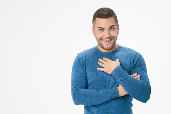 Thankful young man pressing palm to chest against white background — 스톡 사진