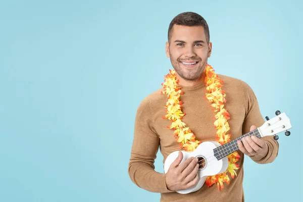 Portrait of handsome male playing ukulele standing over blue background — 스톡 사진