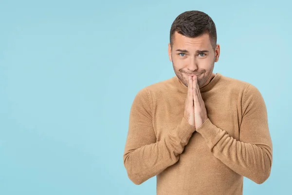 Junger gutaussehender Mann bittet um etwas, hält Palme über isoliertem blauem Hintergrund zusammen — Stockfoto