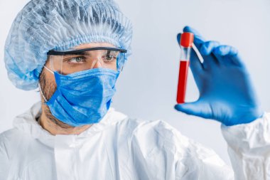 Epidemiyoloji uzmanı virüs karantinasında tıbbi örnek test tüpünü inceliyor ve viral enfeksiyon sırasında kan tahlili yapıyor.