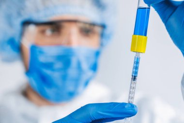 Laboratuvardaki virüs uzmanının elinde olan koronovirüs araştırması ile test tüpünü kapatın.
