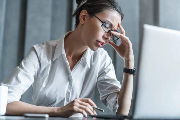 Mujer Joven Trabajadora Oficina Estresada Sentada Escritorio Sosteniendo Cabeza Debido —  Fotos de Stock