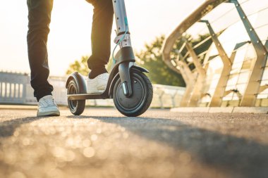 Elektrikli scooter kullanan bir adamın görüntüsünü kapat