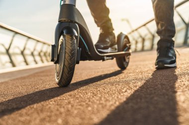 Açık havada elektrikli scooter kullanan adama yakın çekim.
