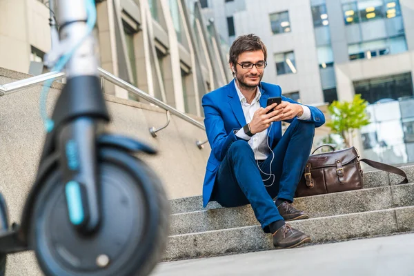 Schöner Junger Geschäftsmann Sitzt Mit Handy Der Nähe Von Elektroroller — Stockfoto