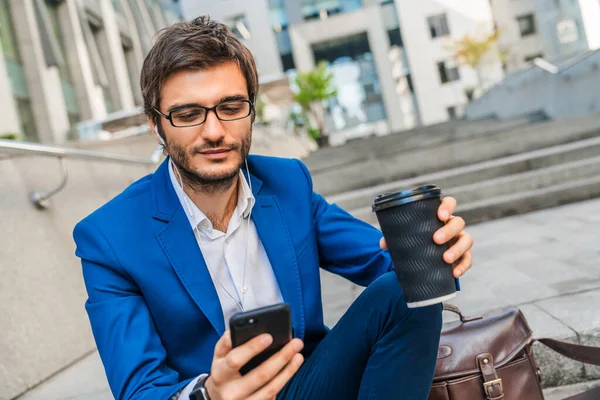 Junger Geschäftsmann Mit Kopfhörern Sitzt Auf Stufen Freien Hält Handy — Stockfoto