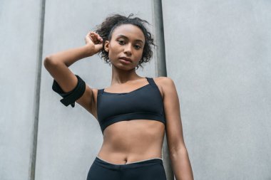 Sabahki antrenmandan sonra dışarıda duran zinde genç bir kadının ön görüntüsü.